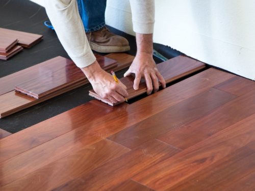 person installing wood flooring